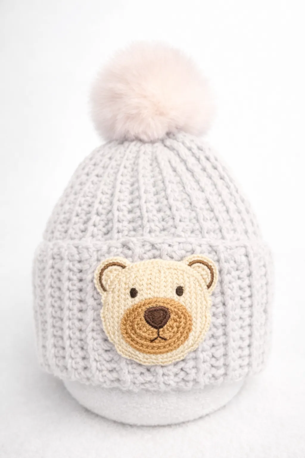 White baby beanie with a bear patch.